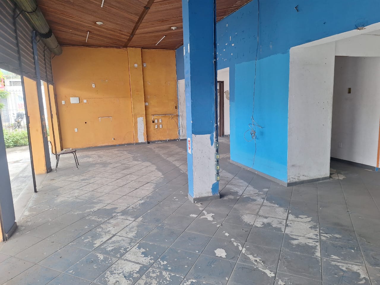 Interior do ponto antes da reforma: paredes azul e laranja, piso gasto e forro de madeira